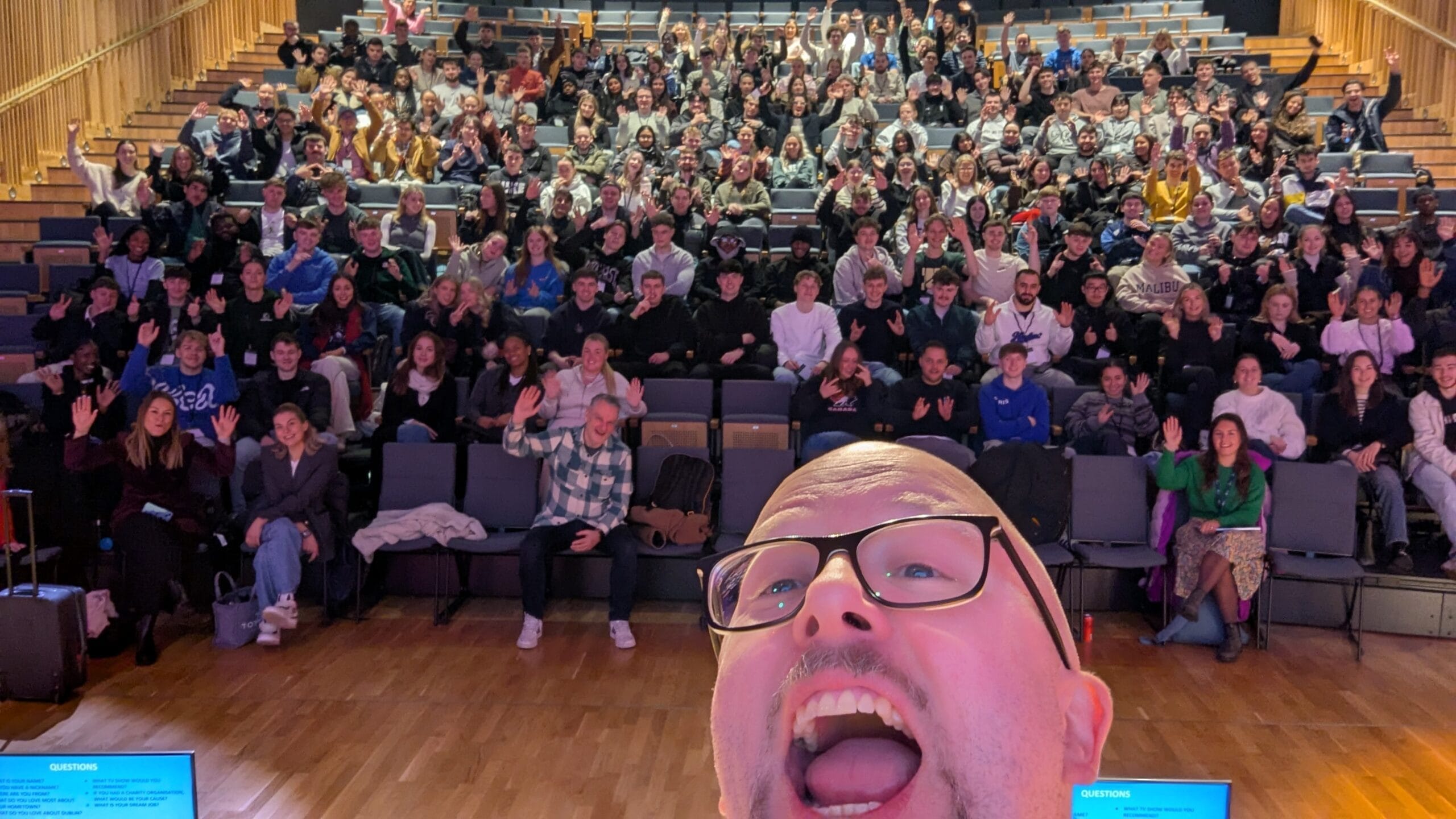 Selfie of Kalle Ryan , roaring happily, with a theatre filled with 200+ international students at International Digital Marketing Week 2025. He was delivering a creative workshop