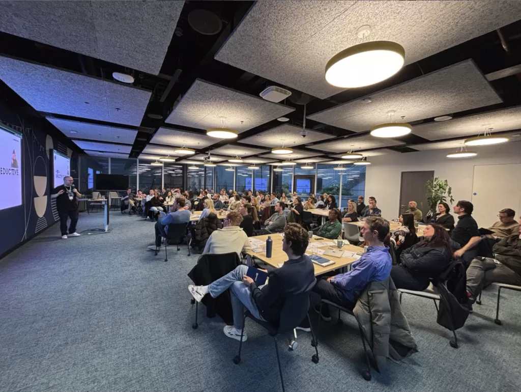 Wide shot of a large conference room at LinkedIn packed to capacity with Kalle Ryan onstage delivering a keynote on storytelling
