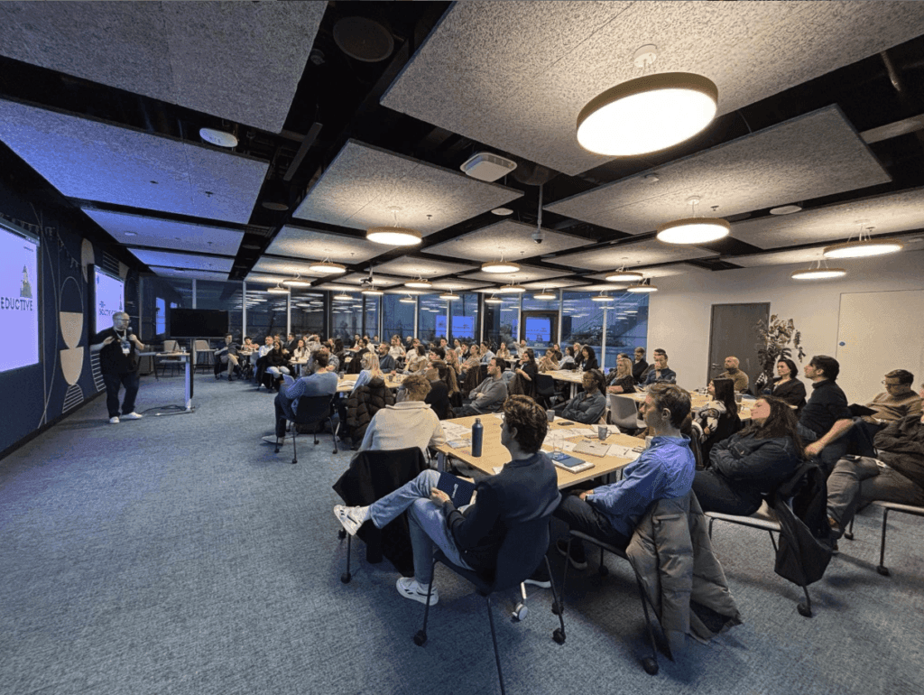 Wide shot of a large conference room at LinkedIn packed to capacity with Kalle Ryan onstage delivering a keynote on storytelling